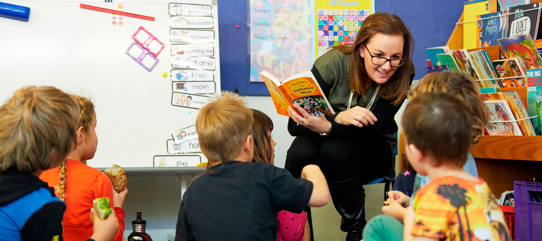 Teacher listening to children on mat