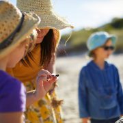 teacher and child looking at shell on the beach