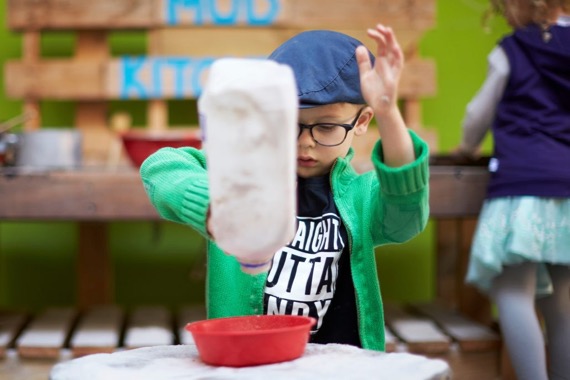 kid playing in mud kitchen