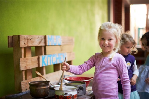 kid playing in mud kitchen